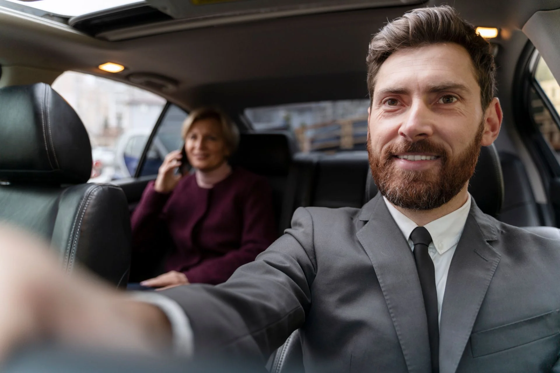 smiling chauffeur driving executive