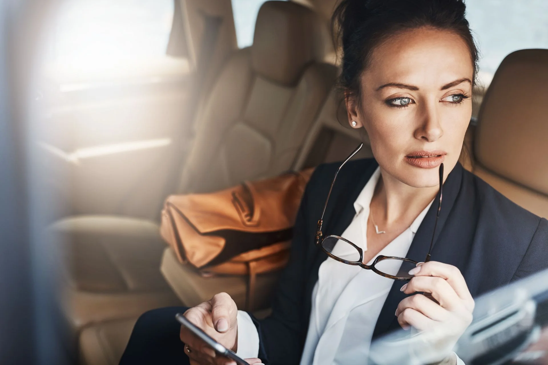 executive woman sitting in backseat of luxury car